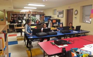 Children in classroom with new laptops.